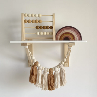 Wooden abacus toy with pastel-colored beads, placed on a neutral surface—ideal for counting and sensory play.