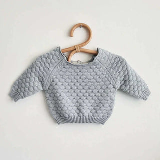 Handmade rattan clothes hangers for kids with woven boho design, nursery-sized and eco-friendly.
