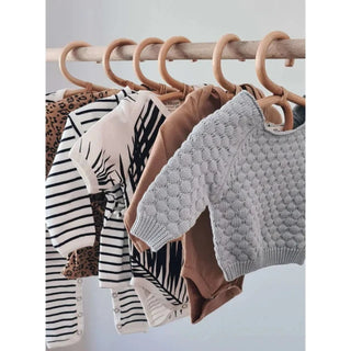 Handmade rattan clothes hangers for kids with woven boho design, nursery-sized and eco-friendly.