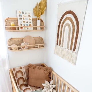 Handmade rattan wall shelf with curved design, styled in a child’s room for displaying books, toys, and keepsakes in a natural Boho aesthetic.