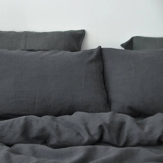 Charcoal grey linen bedding set, styled on a bed with pillows and a cosy duvet, creating an elegant, minimalist bedroom look.