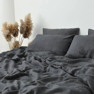 Charcoal grey linen bedding set, styled on a bed with pillows and a cosy duvet, creating a relaxed, minimalist bedroom look.