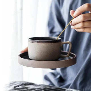 Miri stoneware mug and saucer set with spiral pattern in speckled oatmeal glaze, styled for modern and rustic tableware. Perfect for milk, tea, or coffee.