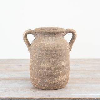 Rustic terracotta vase with aged finish and sculptural form.