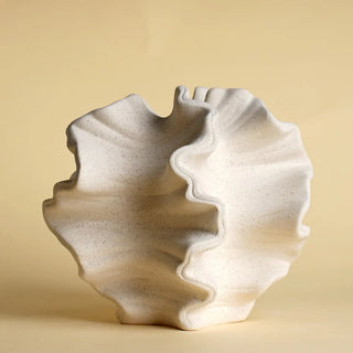 The Pontus Ceramic Vase, a decorative vase inspired by marine life, featuring an organic, coral-like shape with intricate textures and a matte off-white finish. This sculptural piece captures the fluidity of ocean waves, making it a perfect accent for coastal, Japandi, and minimalist interiors. Ideal as a standalone art piece or for dried floral arrangements.
