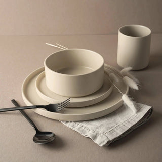 Modern minimalist dinnerware set with a cup, bowl, and plates.