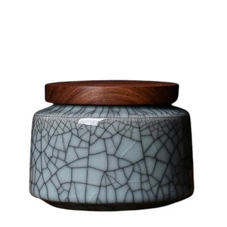 Elegant crackled glaze ceramic storage canister with a dark walnut lid, perfect for kitchen or home organization. Featuring a textured, artisanal design in a soft blue hue, this airtight container is ideal for storing tea, coffee, spices, or small household items. A stylish and functional addition to natural homeware collections.