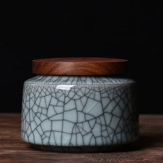Elegant crackled glaze ceramic storage canister with a dark walnut lid, perfect for kitchen or home organization. Featuring a textured, artisanal design in a soft blue hue, this airtight container is ideal for storing tea, coffee, spices, or small household items. A stylish and functional addition to natural homeware collections.Elegant crackled glaze ceramic storage canister with a dark walnut lid, perfect for kitchen or home organization. Featuring a textured, artisanal design in a soft blue hue, this air