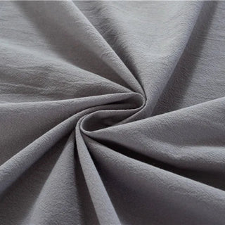 Handmade dark grey cotton tablecloth with soft texture and elegant drape, styled for a modern, minimalist dining setting.