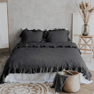 Dark gray ruffled linen pillows and duvet cover on a minimalist bed with a neutral background. Perfect linen bedding set for modern, boho or scandi bedrooms.