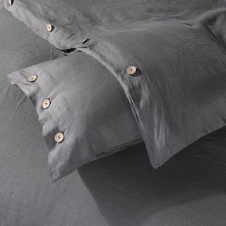 Close up of dark grey linen pillows, sheet and duvet cover with coconut buttons. Perfect for modern, minimalist, scandi or boho bedrooms.