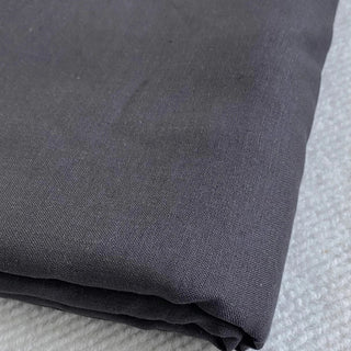 Close up of dark grey linen duvet fabric with a textured surface.