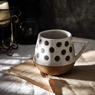 Nordic-inspired handmade clay mug with a white satin-speckled glaze and a dotted motif, perfect for tea or coffee.