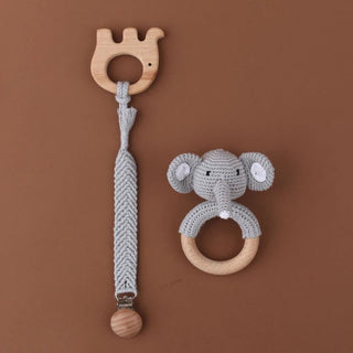 Handmade baby gift set with crochet elephant rattle, wooden teether, and pacifier clip in natural cotton and beechwood.