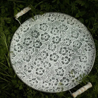 Handmade galvanised metal serving plate with embossed floral pattern and whitewashed wooden handles, styled for rustic or farmhouse tables.