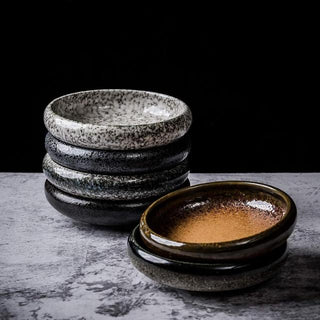 Japanese-inspired artisanal coupe plates with hand-painted glaze, earthy tones, and a matte finish, ideal for gourmet dishes or modern plating.