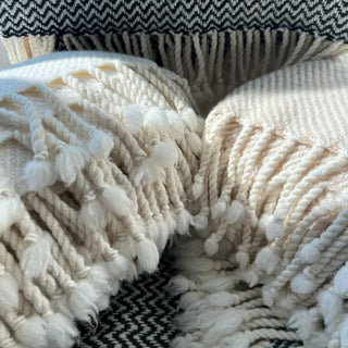 Fine merino wool blankets with hand-tied tassels, premium natural wool texture.