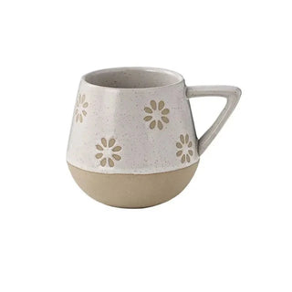Nordic-inspired handmade clay mug with a white satin-speckled glaze and flower motif, perfect for tea or coffee.