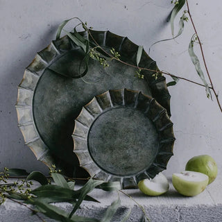 Round fluted galvanized iron tray, a stylish metal serving plate perfect for kitchen tableware. This durable serving plate features fluted rim, adding a touch of elegance to your dining experience. Ideal for both practical use and natural home décor, it enhances your table setting with rustic charm and versatility.