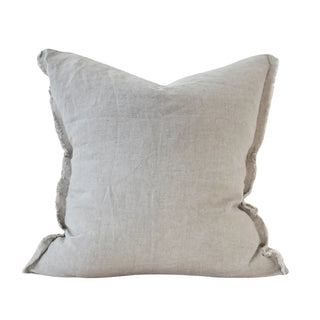 Natural stonewashed linen cushion with frayed edges and soft textured finish.