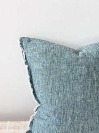 Relaxed linen cushion with organic texture in rich teal green tones for sofas, beds and layered interiors.