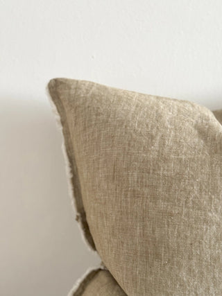 Textured linen cushion in warm olive green tones for sofas, beds and layered interiors.