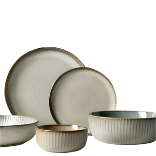 Artisanal ceramic Goku dining plates and bowls, crafted using traditional kiln-glazed methods with a ribbed surface and finished in calming neutral hues inspired by sand and sea. Perfect for serving rice, noodles, steak, salads and more, this dining set adds a touch of elegance to dinner parties and summer socializing.