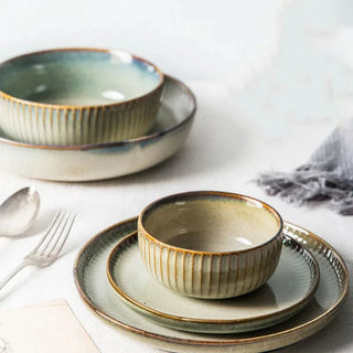 Kiln-glazed ceramic bowls and plates with ribbed surface and earthy, neutral tones inspired by sand and sea—ideal for serving rice, noodles, salads or mains.