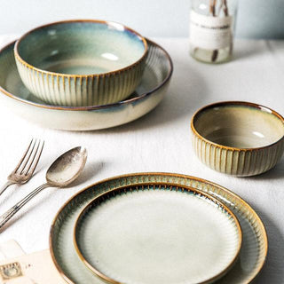 Kiln-glazed ceramic bowls and plates with ribbed surface and earthy, neutral tones inspired by sand and sea—ideal for serving rice, noodles, salads or mains.
