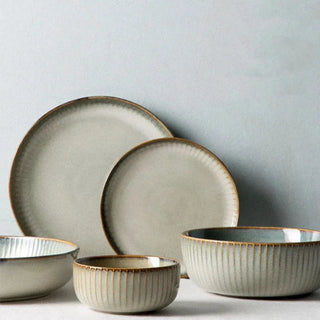 Kiln-glazed ceramic bowls and plates with ribbed surface and earthy, neutral tones inspired by sand and sea—ideal for serving rice, noodles, salads or mains.