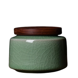 Elegant crackled glaze ceramic storage canister with a dark walnut lid, perfect for kitchen or home organization. Featuring a textured, artisanal design in a soft green hue, this airtight container is ideal for storing tea, coffee, spices, or small household items. A stylish and functional addition to natural homeware collections.