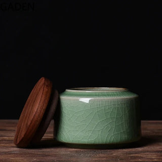 Small green crackled ceramic storage canister with airtight walnut twist lid, perfect for storing tea, coffee, or spices.