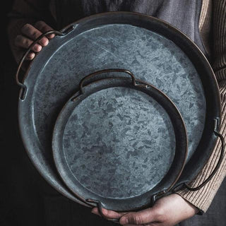 Rustic handmade iron serving plates with handles, ideal for bread, cheese, or decorative farmhouse table styling.