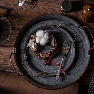 Rustic handmade iron serving plates with handles, ideal for bread, cheese, or decorative farmhouse table styling.