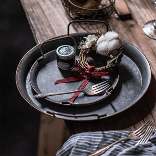 Rustic handmade iron serving plates with handles, ideal for bread, cheese, or decorative farmhouse table styling.