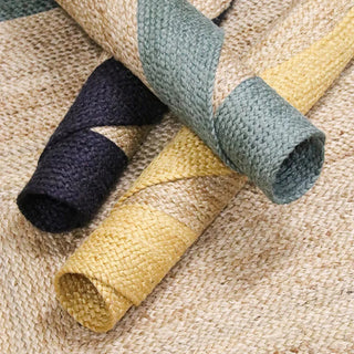 Handmade round reversible jute rug with a natural beige center and a soft blue, yellow or navy border, hand-braided in India from 100% natural jute.
