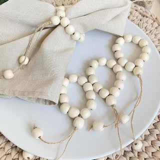 Set of six handmade wood bead napkin rings with whitewashed wood and hemp rope, perfect for natural and eco-styled table settings.