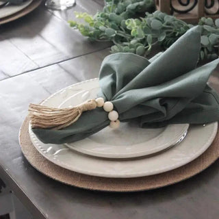 Handmade wood bead napkin rings with whitewashed wood and hemp rope tassels, perfect for natural and eco-styled table settings.