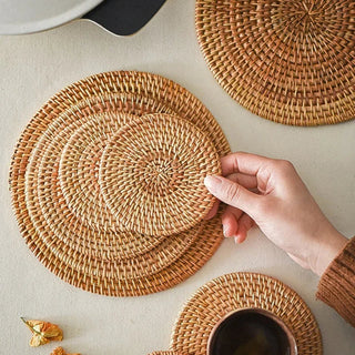 Natural round handwoven rattan placemats and coasters, eco-friendly and heat-resistant for stylish table protection.