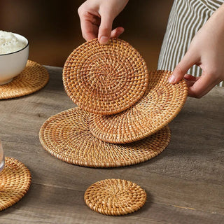 Natural round handwoven rattan placemats and coasters, eco-friendly and heat-resistant for stylish table protection.