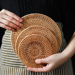 Natural round handwoven rattan placemats and coasters, eco-friendly and heat-resistant for stylish table protection.