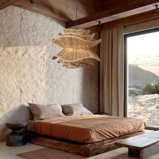 Natural handwoven dark rattan pendant light with organic, wave-like shape and soft ambient glow, ideal for boho and modern interiors.