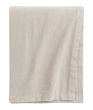 Beige cotton tablecloth with soft texture and elegant drape for modern, minimalist dining setting.
