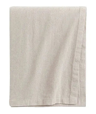 Handmade ivory cotton tablecloth with soft texture and elegant drape, styled for a modern, minimalist dining setting.