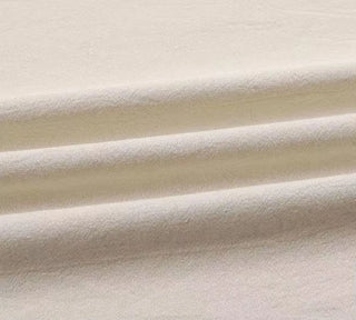 Handmade ivory cotton tablecloth with soft texture and elegant drape, styled for a modern, minimalist dining setting.