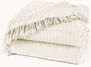 Nori Ivory Cotton Gauze Throw – soft and lightweight natural blanket with textured weave and fringed edges. Perfect for layering over a bed or sofa for a relaxed, cozy and lived-in look.