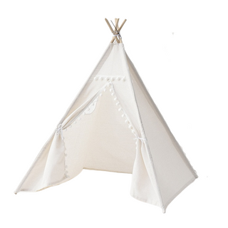 Whimsical cotton teepee play tent with pom poms for children. Boho-style play tent for nursery or bedroom.