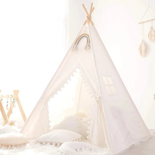 Whimsical cotton teepee play tent with pom poms for children. Boho-style play tent for nursery or bedroom.