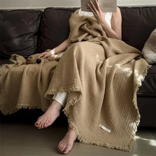 Nori Latte Cotton Gauze Throw – soft and lightweight natural blanket with textured weave and fringed edges. Perfect for layering over a bed or sofa for a relaxed, cozy and lived-in look.