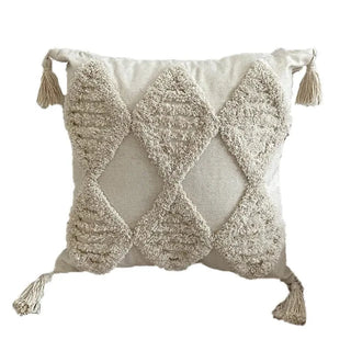 Tufted cotton cushion cover with  geometric pattern on the front and tasselled corners.